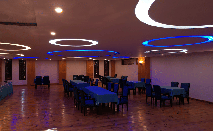 An indoor banquet hall showcasing elegantly decorated seating arrangements at Digantaa Resort in Mukteshwar