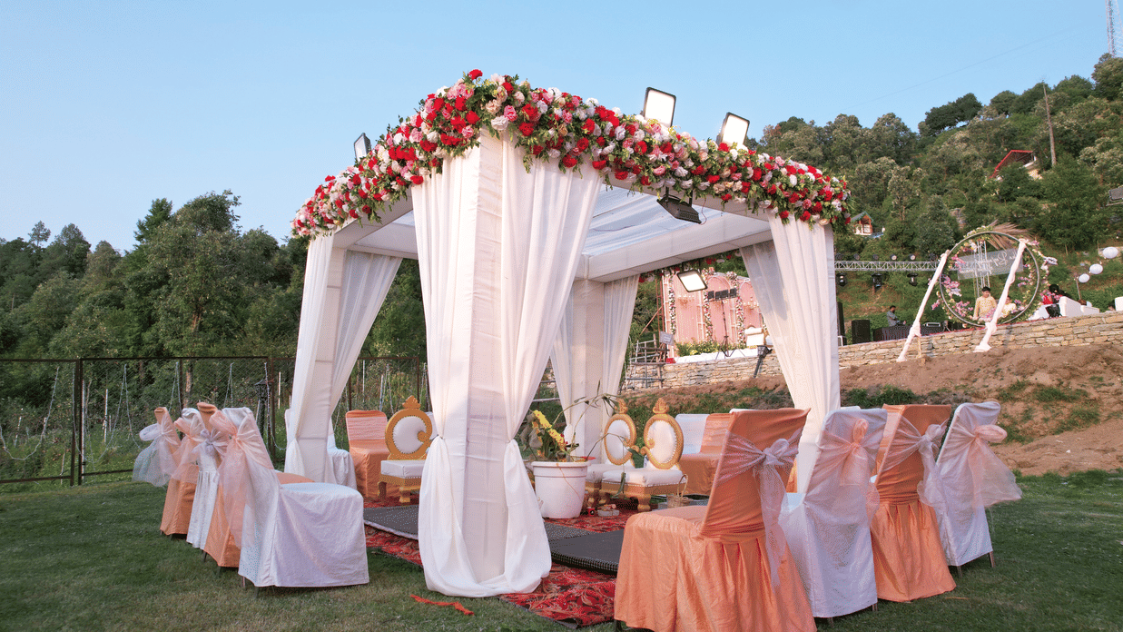 Ornate wedding mandap adorned with red and white flowers and flowing white fabric - Digantaa Resort in Mukteshwar
